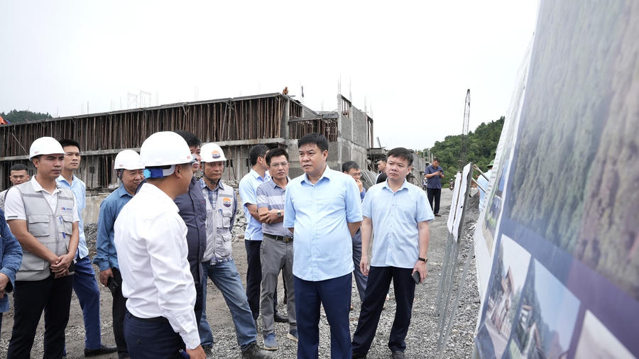 Ông Hoàng Gia Long (đứng thứ hai từ phải sang), Phó Chủ tịch UBND tỉnh Tuyên Quang nghe báo cáo tiến độ triển khai Dự án Trường Phổ thông Dân tộc nội trú liên cấp Tiểu học và THCS Sơn Vĩ. (Ảnh: Hà Linh).