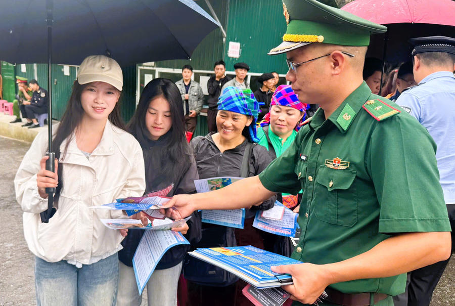 Đồn Biên phòng Phó Bảng, Bộ đội Biên phòng tỉnh Tuyên Quang phát tờ rơi tuyên truyền đến người dân. (Ảnh: Thái An).
