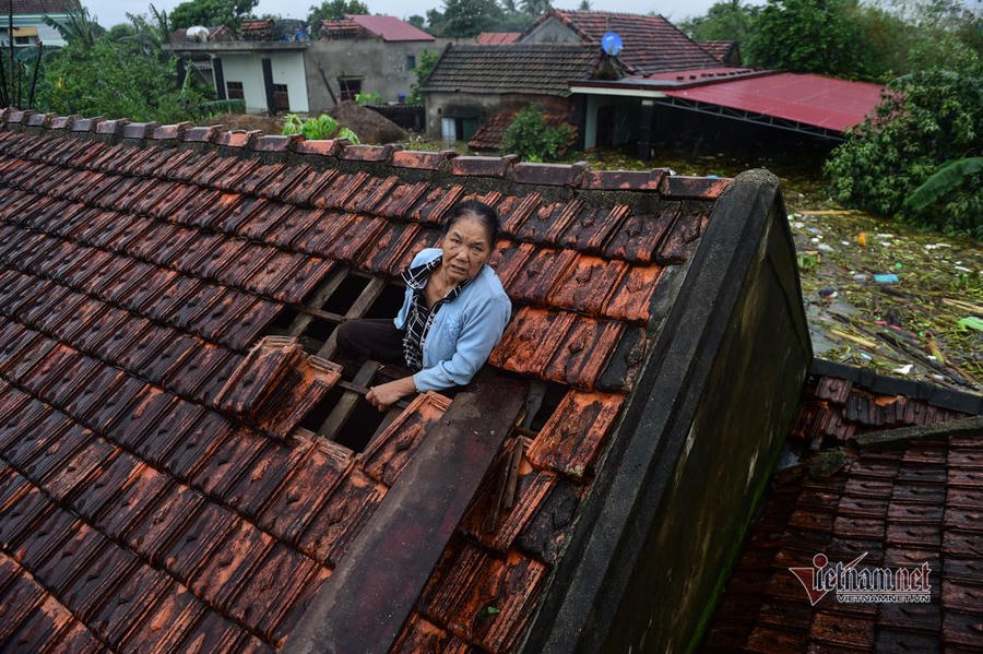 Người dân tại xã Sơn Thuỷ, huyện Lệ Thuỷ leo lên mái nhà chờ sơ tán. Ảnh Vietnamnet