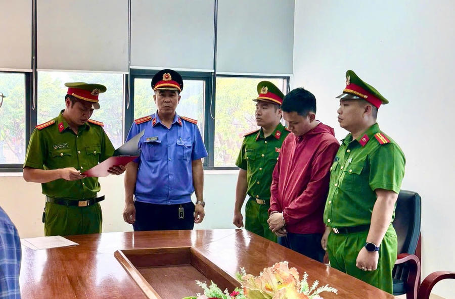 Tổng đạt quyết định bắt bị can để tạm giam đối với Lê Văn Thành (áo đỏ) - Ảnh Công an Quảng Trị.