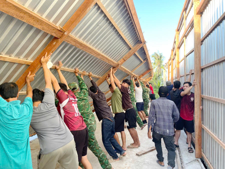 Cán bộ, chiến sĩ Đồn Biên phòng Đất Mũi cùng chính quyền địa phương và người dân dựng lại nhà cho hộ bà Quỳnh.