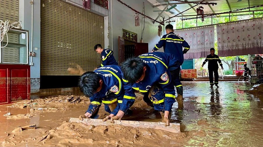 Cán bộ Phòng Cảnh sát phòng cháy, chữa cháy và cứu nạn, cứu hộ hỗ trợ nhân dân gạt bùn.