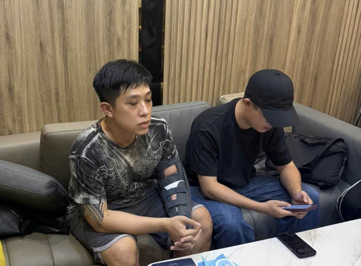 Đối tượng Vũ Quang Huy (tay có hình xăm) tại cơ quan công an. Ảnh: CACC