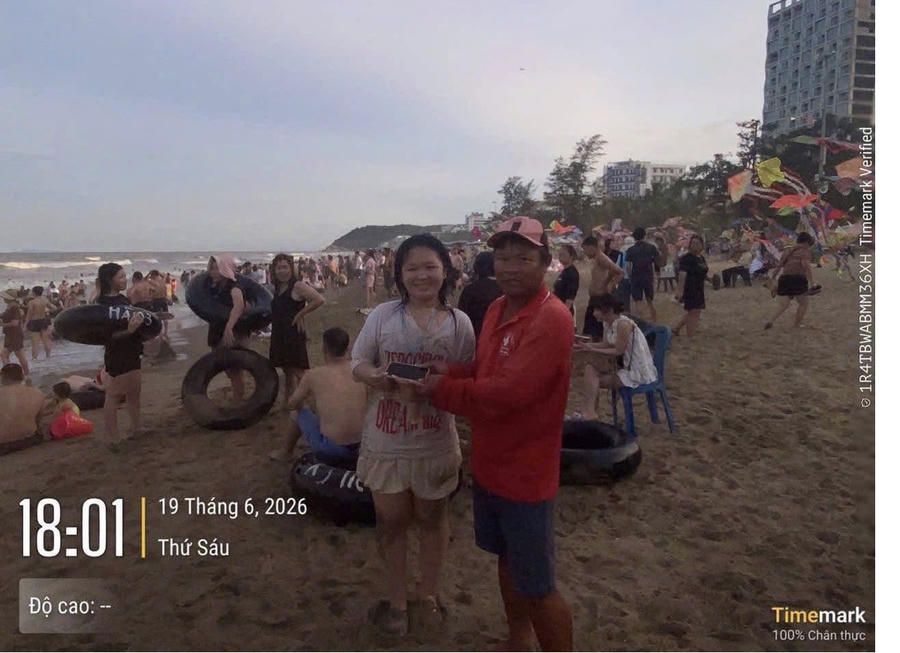 Anh Cao Văn Tâm (nhân viên Đội Cấp cứu biển) trao lại chiếc điện thoại bị thất lạc cho du khách.