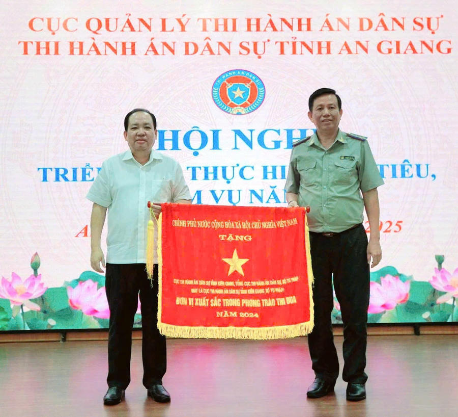 Ông Nguyễn Thanh Phong - Phó Chủ tịch Thường trực UBND tỉnh An Giang (bên trái) tặng Cờ thi đua của Chính phủ cho THADS tỉnh An Giang vì đạt thành tích xuất sắc, dẫn đầu thi đua yêu nước năm 2024.