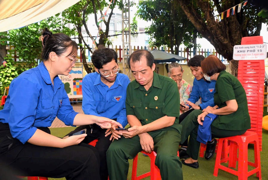 Đội hình xung kích “1-2-3” của TP HCM hướng dẫn người dân sử dụng ứng dụng VNeID. (Ảnh: Cổng TTĐT TP HCM)