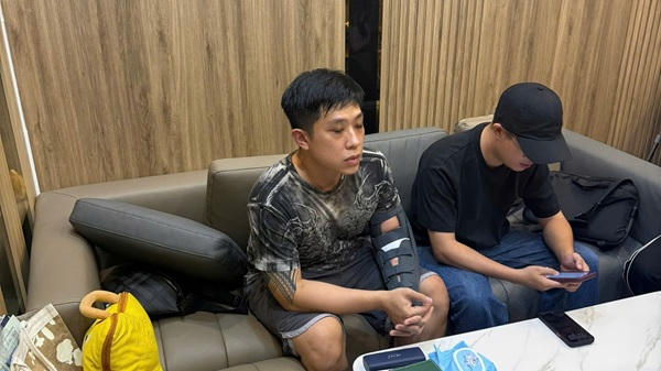 Bị can Vũ Quang Huy (tay có hình xăm) tại cơ quan công an. Ảnh: CACC