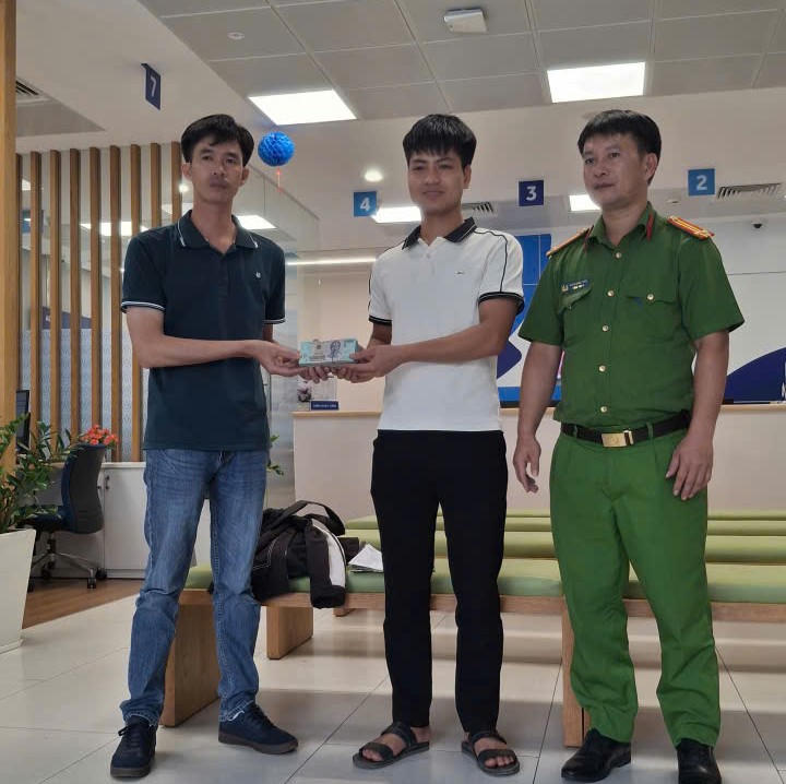 Anh Nguyễn Tiến Huy (áo trắng) gửi lại tiền cho Cán bộ Công an xã Bình Lợi.