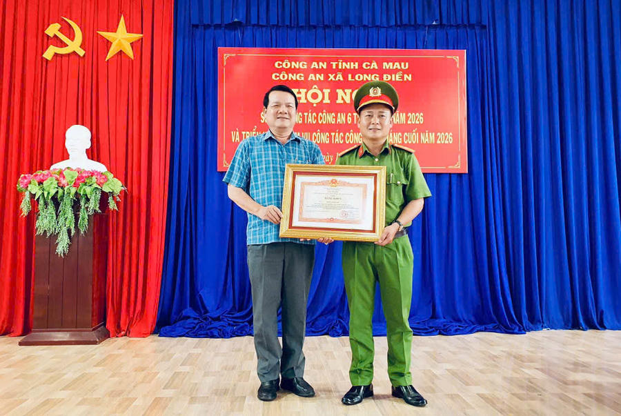 Thừa ủy quyền, ông Nguyễn Nam Quân – Bí thư Đảng ủy xã Long Điền, trao Bằng khen của Thủ tướng Chính phủ cho Thiếu tá Phạm Tấn Thanh tại Hội nghị sơ kết công tác Công an 6 tháng đầu năm 2026.