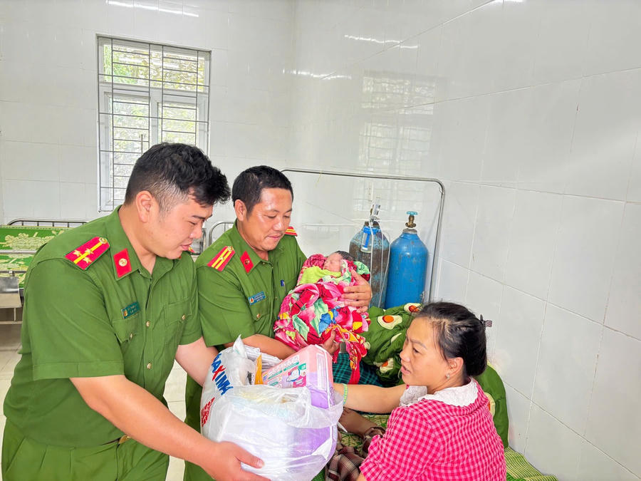 Thiếu tá Lý Phùy Chóng cùng đồng đội chúc mừng và tặng quà mẹ con sản phụ Lỳ Mì Hoa.