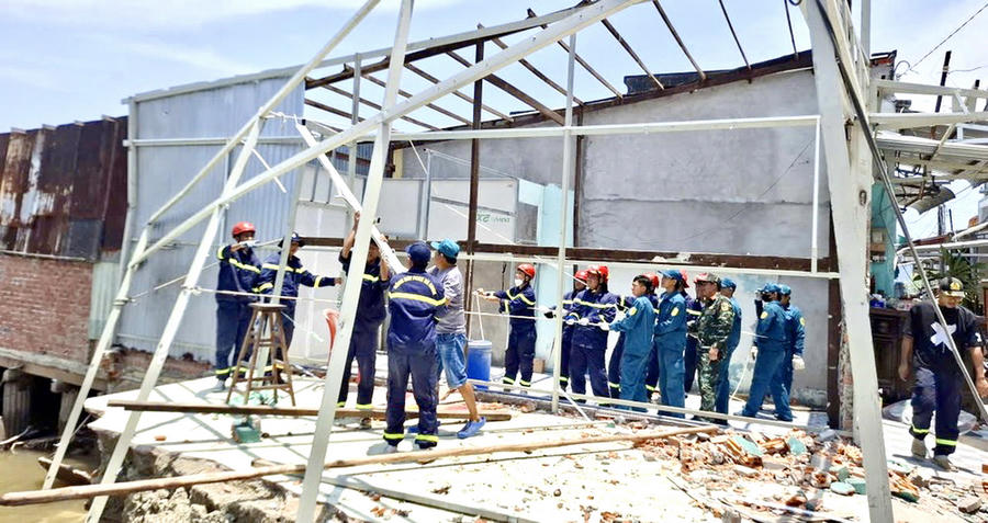 Lực lượng Công an và Quân sự khẩn trương hỗ trợ người dân khắc phục thiệt hại do sạt lở xảy ra tại khóm 13, phường Tân Thành, ngày 21/4.