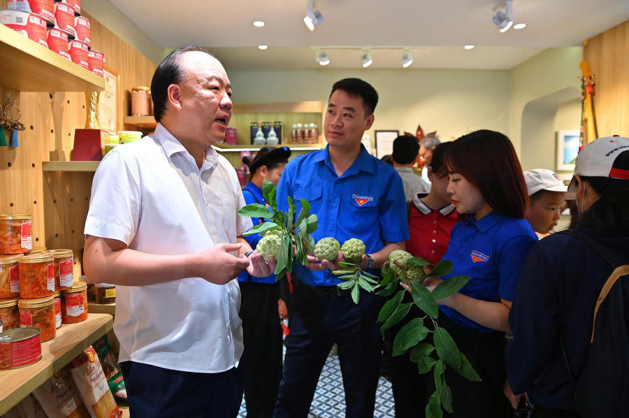 Ông Trần Hữu Linh - Cục trưởng Cục Quản lý và Phát triển thị trường trong nước, Bộ Công Thương (bìa trái); Bí thư tỉnh Đoàn Lạng Sơn (ảnh giữa) và Ủy viên Ban Chấp hành Trung ương Đoàn khóa XIII, Bí thư Đoàn Thanh niên Bộ Công Thương tham quan gian hàng quảng bá, giới thiệu Na Chi Lăng. Ảnh: DMS