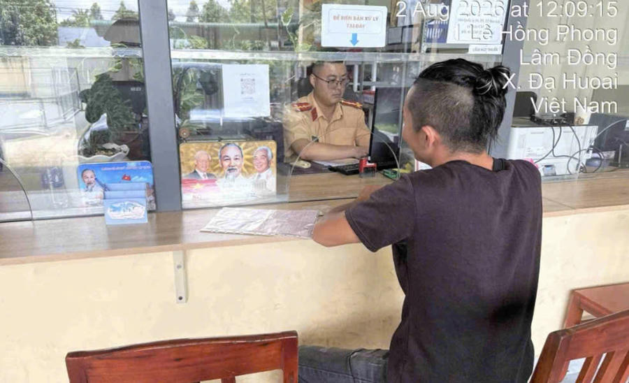 Tài xế T.T.P điều khiển xe ôtô tải vượt ẩu và sử dụng điện thoại khi lưu thông trên đèo Bảo Lộc đang làm việc với cán bộ công an. Ảnh: Trạm Cảnh sát giao thông Madaguoi