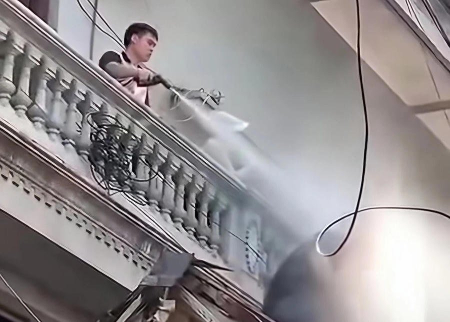 Nguyễn Duy Mạnh dùng vòi xịt nước để cản trở việc thi hành án. Ảnh cắt từ clip