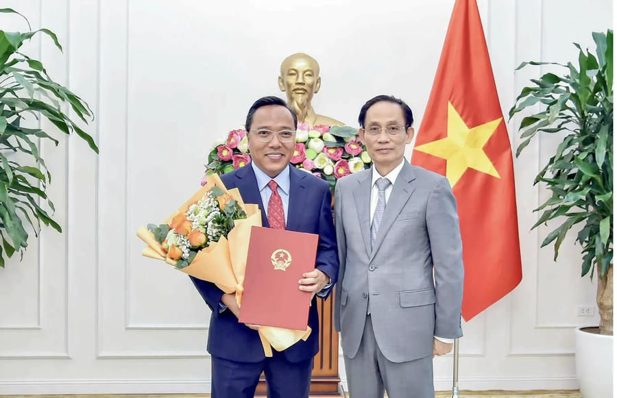 Bộ trưởng Bộ Ngoại giao Lê Hoài Trung trao quyết định của Thủ tướng Chính phủ và tặng hoa chúc mừng ông Nguyễn Hoàng Long được điều động, bổ nhiệm giữ chức Thứ trưởng Bộ Ngoại giao. Ảnh: VGP