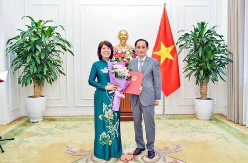 Bộ trưởng Bộ Ngoại giao Lê Hoài Trung trao quyết định của Thủ tướng Chính phủ và tặng hoa chúc mừng bà Nguyễn Thị Hoàng Vân được điều động, bổ nhiệm giữ chức Thứ trưởng Bộ Ngoại giao. Ảnh: VGP