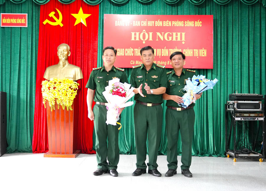 Đại tá Hà Văn Thanh, tặng hoa chúc mừng Trung tá Đỗ Văn Lanh (bên trái) và Trung tá Trương Văn Kết (bên phải) nhận nhiệm vụ mới.