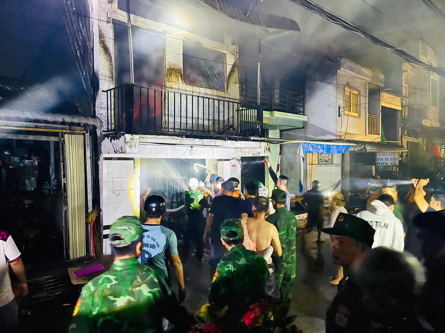 Cán bộ, chiến sĩ Đồn Biên phòng Sông Đốc phối hợp với các lực lượng chức năng khẩn trương dập lửa, ngăn cháy lan sang các nhà dân lân cận.