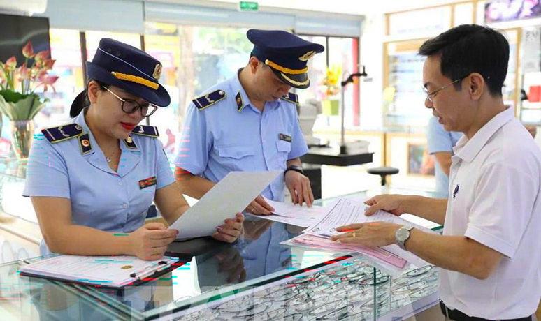 Kiểm soát viên Đội 6, Quản lý thị trường Tuyên Quang tuyên truyền và ký cam kết với hộ kinh doanh về việc bán hàng hóa có xuất xứ rõ ràng.