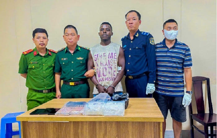 Lực lượng chức năng bắt quả tang đối tượng nhận kiện hàng có cất giấu ma túy.