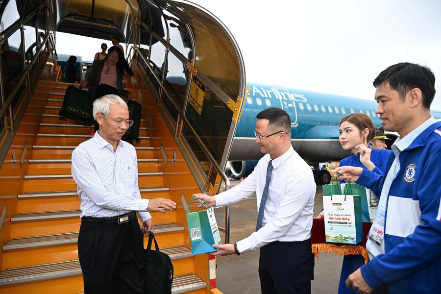 Sau khi tàu bay hạ cánh, Cục trưởng Cục Hàng không Việt Nam ông Uông Việt Dũng vui mừng tặng quà lưu niệm cho hành khách chuyến bay. (Ảnh: Cục Hàng không Việt Nam)
