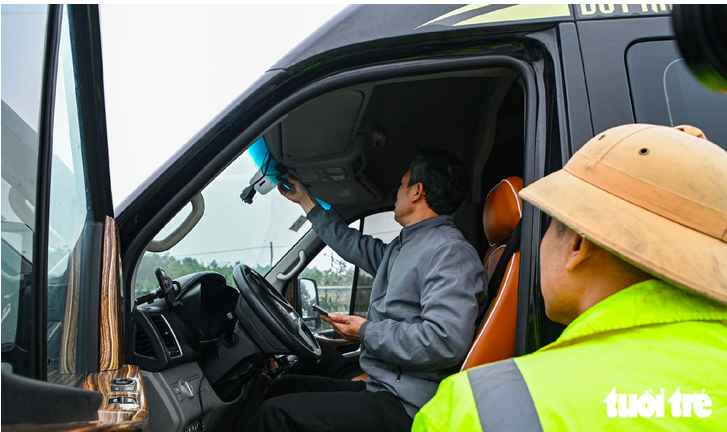 Cảnh sát giao thông kiểm tra thiết bị giám sát lắp trên xe kinh doanh vận tải - Ảnh: HỒNG QUANG
