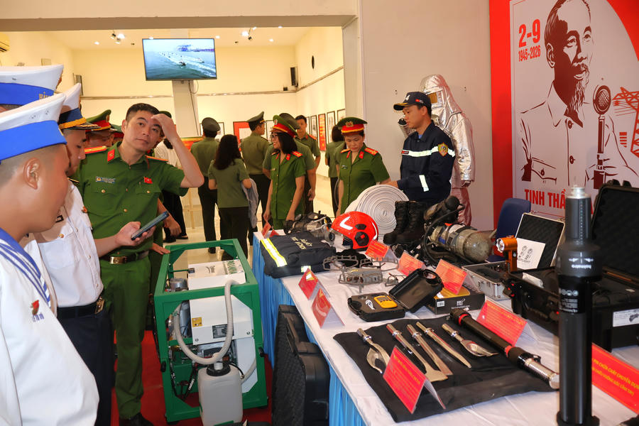 Cán bộ, chiến sĩ và học sinh tham quan, tìm hiểu hình ảnh, tư liệu cùng các trang thiết bị được trưng bày tại triển lãm.