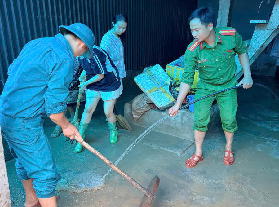 Lực lượng chức năng xã Mường Chanh giúp các gia đình bị ảnh hưởng di dời tài sản, dọn dẹp bùn đất tràn vào nhà.