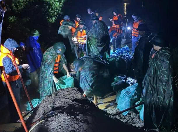 Cán bộ, chiến sĩ Sư đoàn 395 (Quân khu 3) cùng chính quyền địa phương và nhân dân đắp đất, gia cố thân đê, xử lý các vị trí nước tràn.