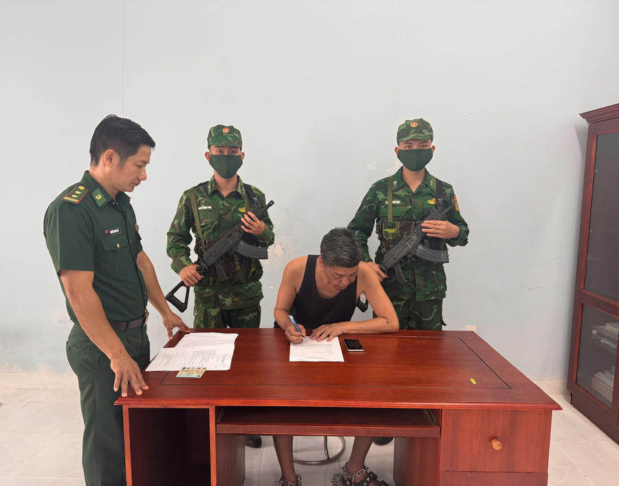 Trung tá Nguyễn Minh Trí, Phó Đồn trưởng Nghiệp vụ đang hướng dẫn ông Onomura Hiromitsu mang quốc tịch Nhật Bản viết lời khai (ảnh: Hải Bằng)