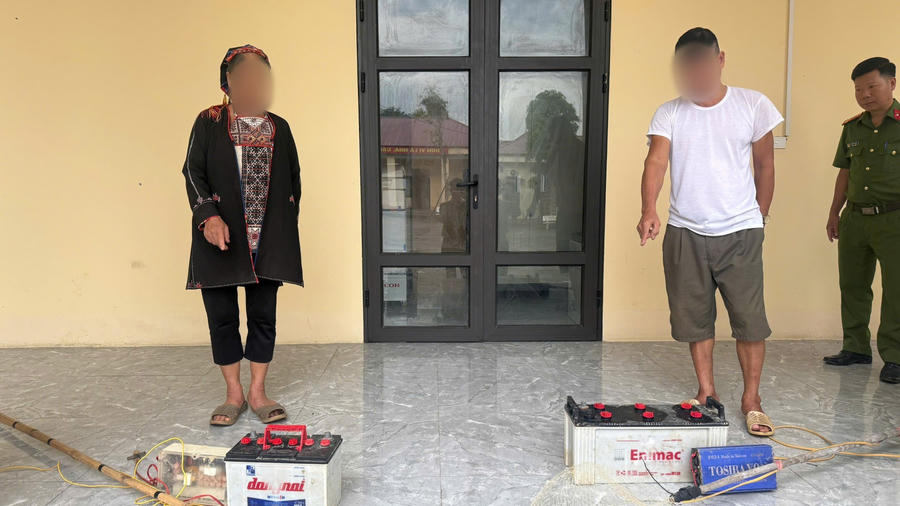 Hai người vi phạm cùng tang vật là công cụ kích điện dùng để khai thác thủy sản trái phép. (Ảnh: Công an Lào Cai).