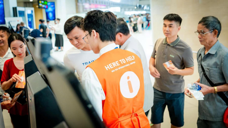 Nhân viên trợ giúp hành khách (áo cam) hỗ trợ hành khách quét sinh trắc học. (Ảnh: Cục HKVN)