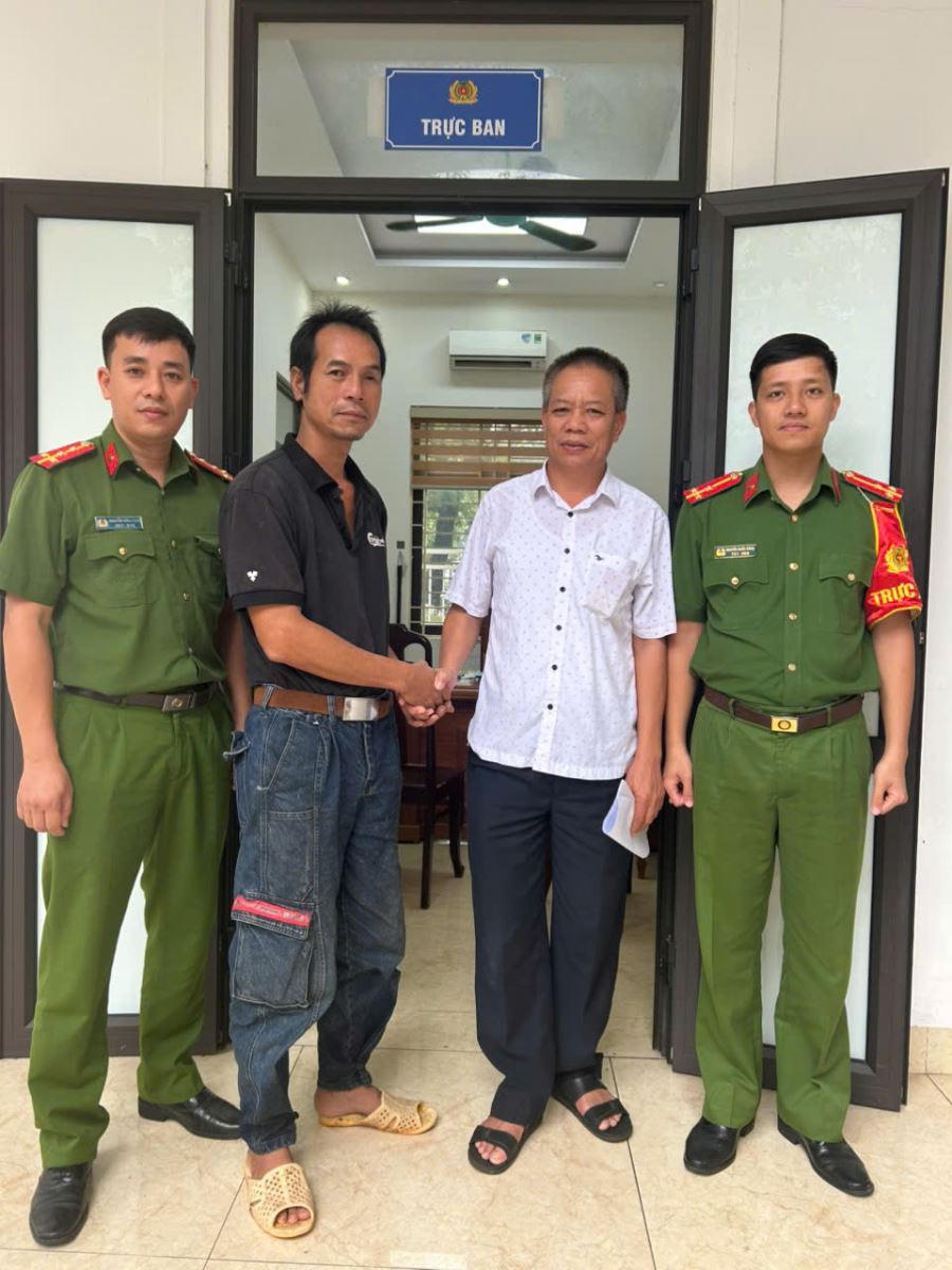 Anh Đoàn Ngọc Hội nhận lại tiền chuyển khoản nhầm từ ông Ngô Ngọc Huy tại cơ quan Công an.