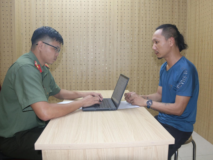Đại diện Cơ quan An ninh điều tra làm việc với bị can Thân Văn Tấn (Ảnh: Nguyễn Trang).