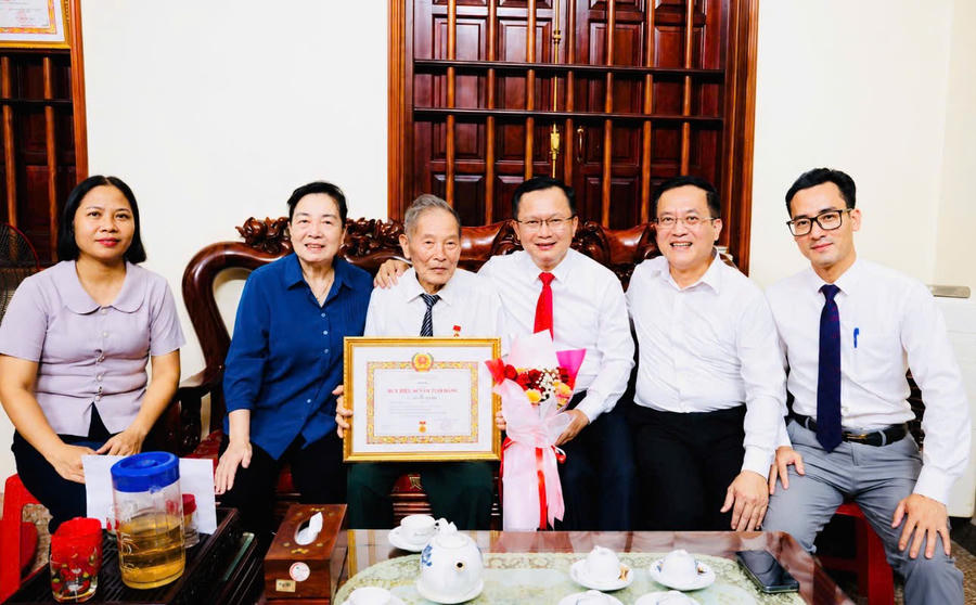 Niềm vui của đảng viên lão thành Phạm Học khi đón nhận Huy hiệu Đảng cùng sự quan tâm, chúc mừng của lãnh đạo Đặc khu Vân Đồn và gia đình.