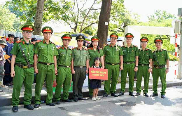 Cán bộ, chiến sĩ Công an phường Ba Đình phát nước uống miễn phí cho người dân và du khách vào Lăng viếng Bác.