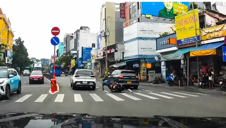 Va chạm khiến người đi xe máy té ngã xuống đường, tài xế ô tô không dừng lại mà tiếp tục cho xe di chuyển. Ảnh cắt từ clip