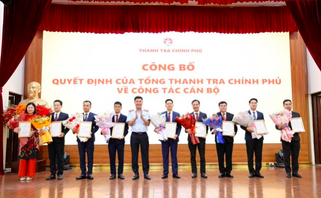 Phó Tổng Thanh tra Chính phủ Nguyễn Văn Cường trao quyết định và tặng hoa chúc mừng 9 sĩ quan công an biệt phái về cơ quan này (Ảnh: TTCP).
