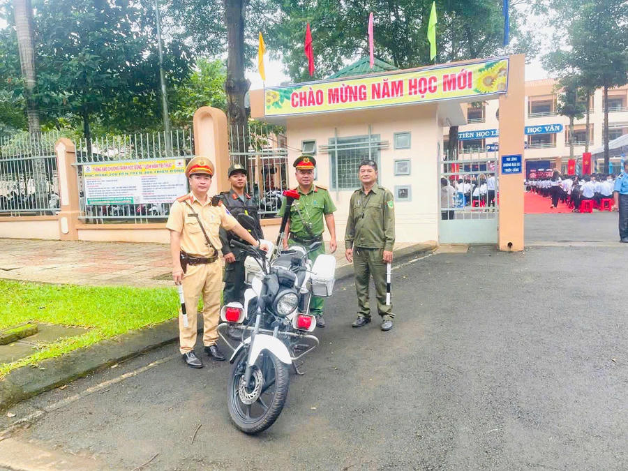 Lực lượng Cảnh sát giao thông cùng Công an cơ sở túc trực tại cổng trường, chủ động phân luồng và bảo đảm an toàn trong lễ khai giảng. Ảnh: CACC