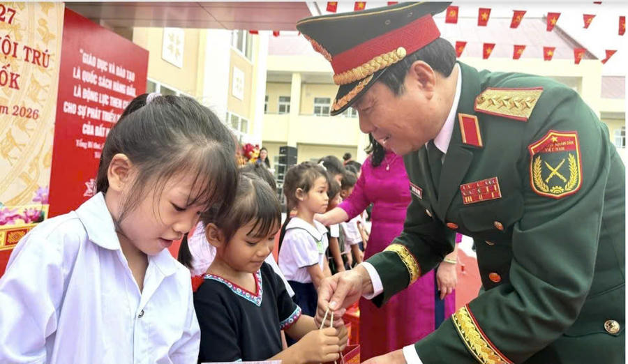 Đại tướng Nguyễn Tân Cương - Ủy viên Trung ương Đảng, Tổng Tham mưu trưởng Quân đội nhân dân Việt Nam, Thứ trưởng Bộ Quốc phòng, tặng quà cho các em học sinh. Ảnh: N.G