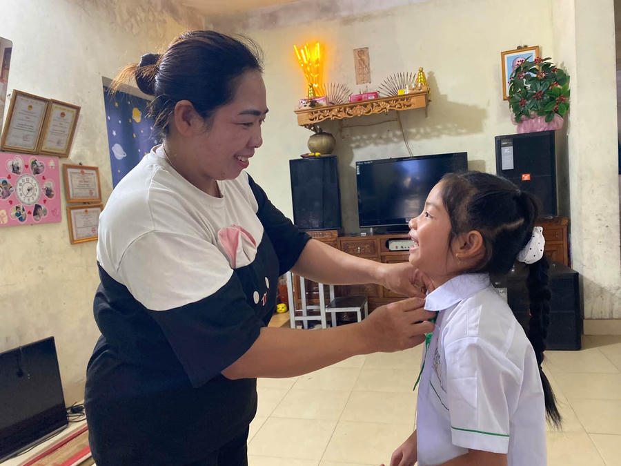 Chị Hoàng Thị Quang chỉnh trang phục cho con gái Vũ Khánh Ngọc trước giờ dự lễ khai giảng tại điểm trường Liên cấp đảo Trần.