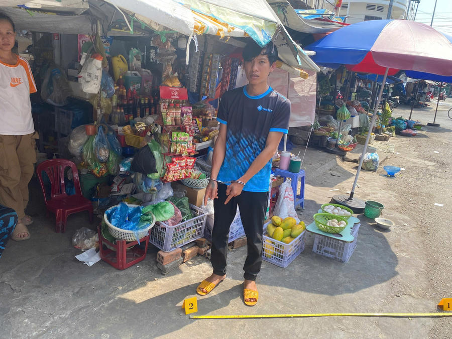 Đối tượng Đỗ Quốc Trung và Hồ Ngọc Luân thực nghiệm lại hành vi sử dụng tiền giả. Ảnh: Công an Lâm Đồng