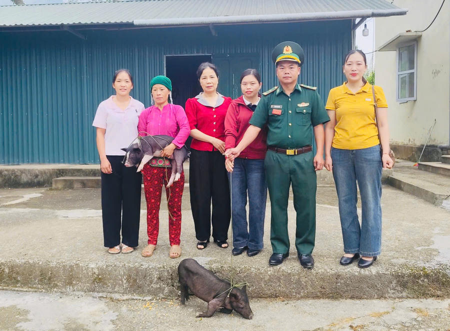 Đồn Biên phòng Nghĩa Thuận trao lợn giống cho hội viên phụ nữ tại xã biên giới Cán Tỷ. (Ảnh: Hoàng Chính).