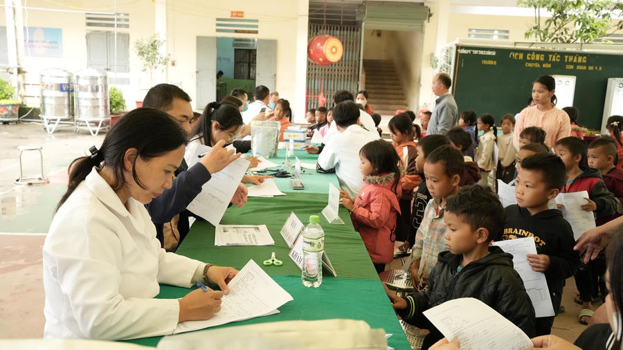 Bác sĩ khám tai cho học sinh trong chương trình khám sức khỏe, sàng lọc miễn phí tại xã Sơn Vĩ.