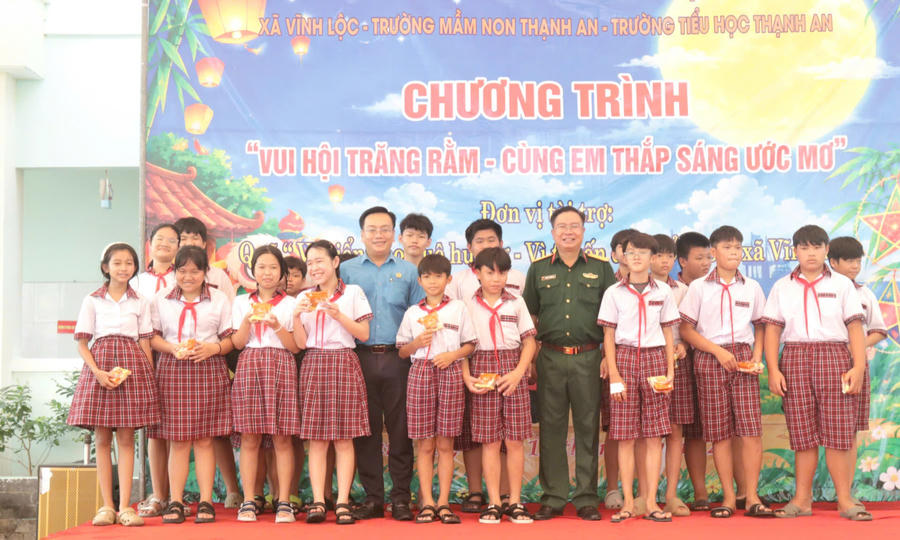 Đại diện lãnh đạo xã Vĩnh Lộc trao quà cho các em thiếu nhi - (Ảnh: Lê Tú)