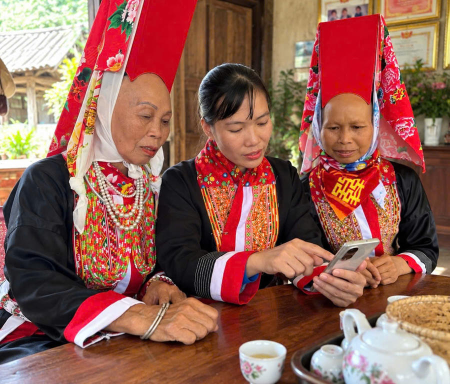 Lỷ Thị Vân hướng dẫn bà con Dao sử dụng điện thoại thông minh, đưa thông tin đến gần hơn với người dân.