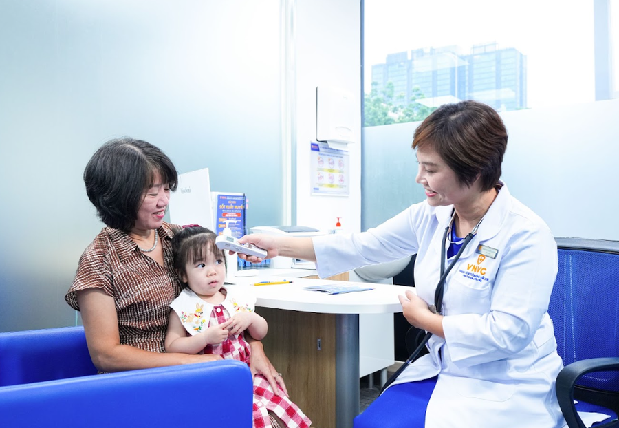 Bà Nguyễn Thị Minh Nguyệt (phường Phúc Lợi) đưa cháu gái Thảo Tiên (24 tháng tuổi) đến tiêm phòng bệnh. Ảnh: Anh Tuấn