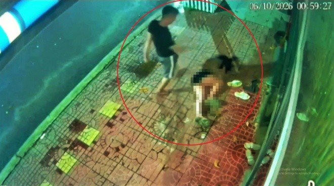 Chồng đuổi đánh, hành hung vợ đến bất động trên vỉa hè. Ảnh cắt từ clip.