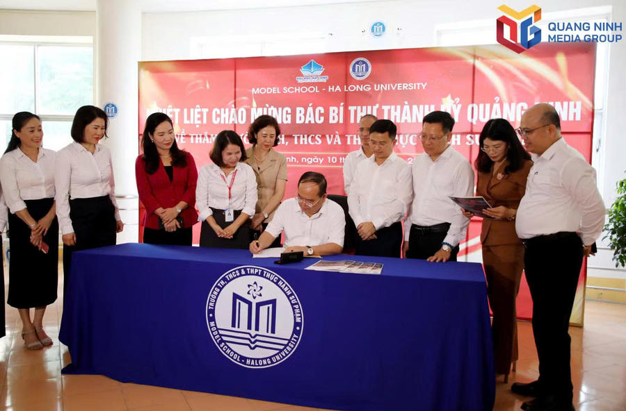 Bí thư Thành ủy ghi sổ lưu niệm nhà trường.Ảnh: Báo Quảng Ninh