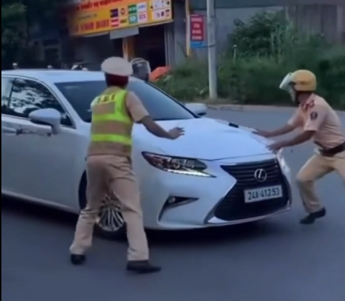 Người điều khiển ô tô chốt cửa, nổ máy, tăng ga bỏ chạy dù lực lượng CSGT Lào Cai liên tục ra hiệu lệnh dừng xe. Ảnh cắt từ clip.